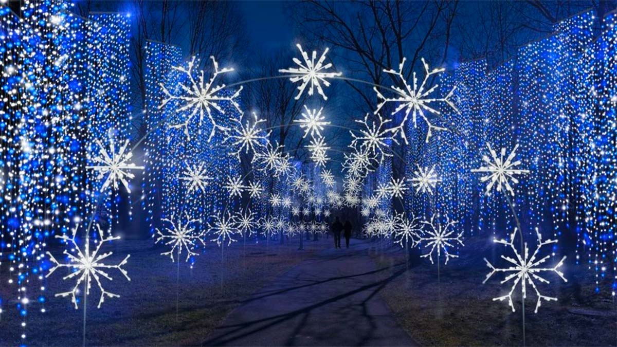 couple walking through path surrounded by lights at night at Winterfest Wonders of Light Walking Trail in Pigeon Forge, Tennessee, USA